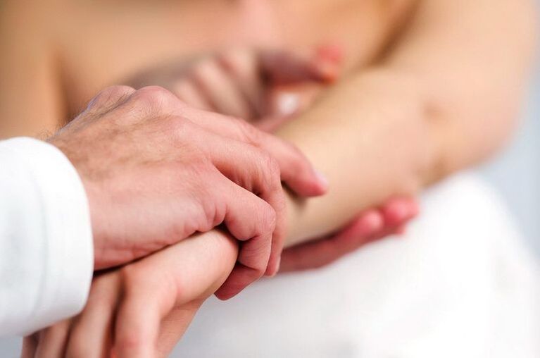 Dermatolog vyšetřující pacienta s psoriázou